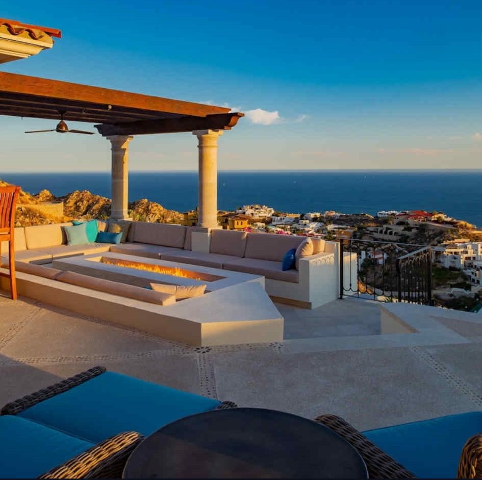 A serene landscape depicting a sunset over a tranquil lake surrounded by trees and mountains.