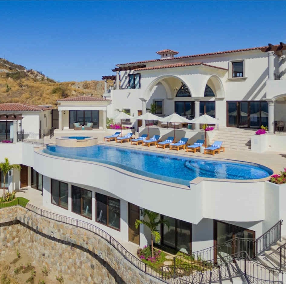 A serene landscape featuring mountains, a lake, and lush greenery under a clear blue sky.